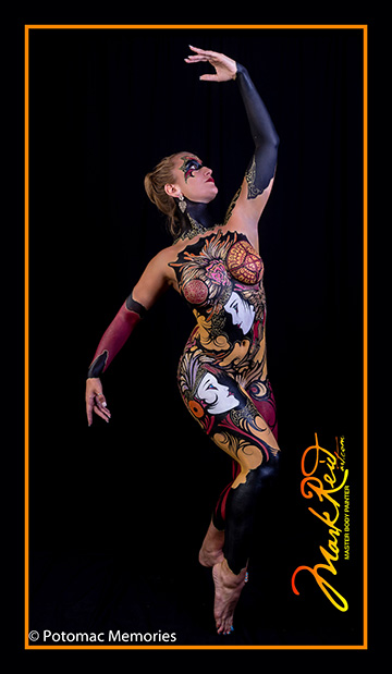 Model in colorful full body paint with left arm raised up