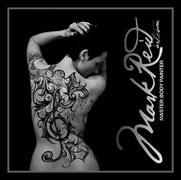 Black and white image of a dark haired woman with an extremely intricate painting on her back