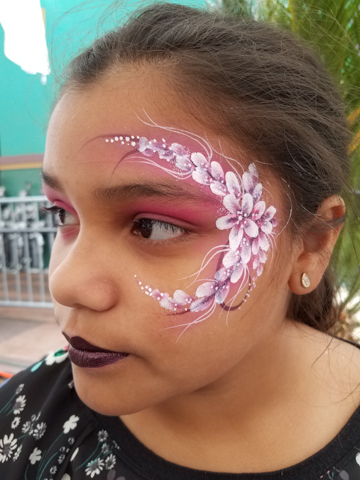 girl in a very delicate painting of white flowers with a pink background and pink highlights around her left eye